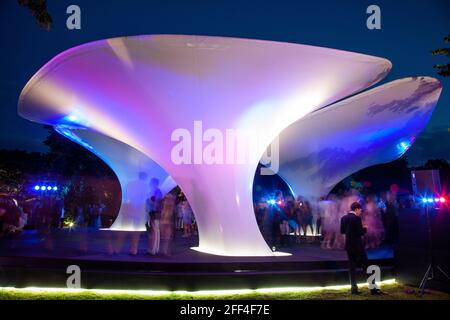 Crowds of people gathering outside Lilas, for the Serpentine summer party. Lilas Pavilion - Serpentine Gallery, London, United Kingdom. Architect: Zah Stock Photo