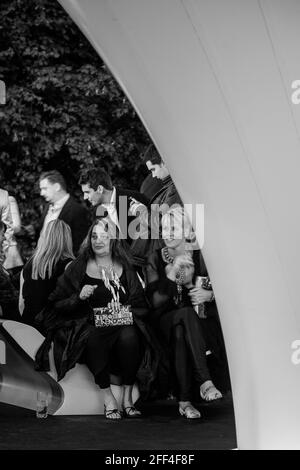 Crowds of people gathering outside Lilas, for the Serpentine summer party. Lilas Pavilion - Serpentine Gallery, London, United Kingdom. Architect: Zah Stock Photo