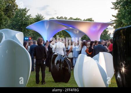 Crowds of people gathering outside Lilas, for the Serpentine summer party. Lilas Pavilion - Serpentine Gallery, London, United Kingdom. Architect: Zah Stock Photo