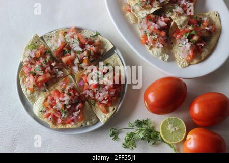 Crisp and fried papads topped with a masala filling of onions, tomatoes and spices. Popular starter from North India commonly known as masala papad. S Stock Photo