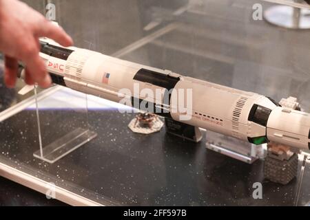 A shopper pointing at a replica of Saturn 5 rocket built in Lego at a