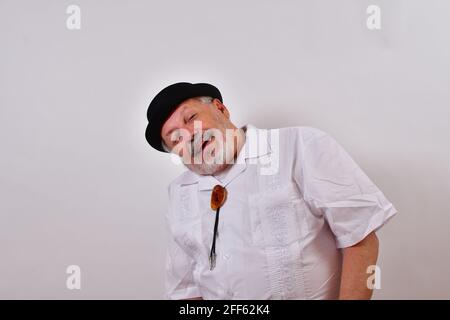 View of an elderly man smiling and enjoying the view wearing a shirt and a hat on white Stock Photo