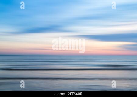 An intentionally blurred image created by panning the camera during a long exposure on the beach at Crosby near Liverpool at dusk. Stock Photo