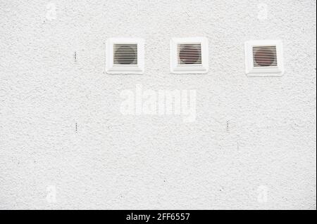 White plastic air vents on plain background house wall Stock Photo