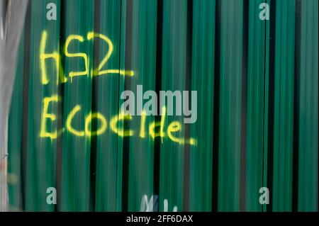 Denham, Buckinghamshire, UK. 24th April, 2021. HS2 Ecocide grafitti next to an HS2 compound. The High Speed Rail link from London to Birmingham puts 693 wildlife sites, 108 ancient woodlands and 33 SSSIs at risk. Credit: Maureen McLean/Alamy Stock Photo