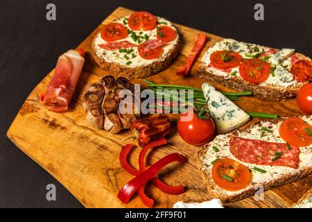 Healthy food rye bread with cream cheese and tomato. Sliced tomatoes with bread. Baked garlic with cheese and ham. Stock Photo