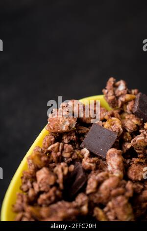 Cereals of chocolate with little chocolates in a yellow pot on a black table Stock Photo