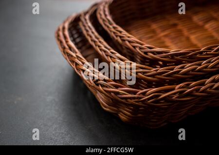 Some brown handmade baskets on a black wooden table Stock Photo