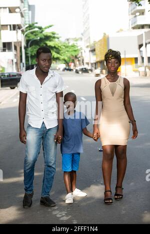 Happy family, father, mother and their sons walking on the street in a sunny day Stock Photo