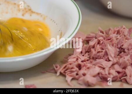 rapidly stirring raw eggs in a bowl with a whisk Stock Photo