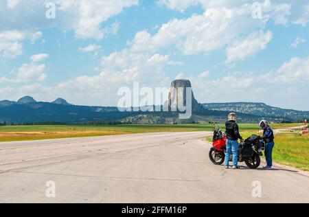 Bikers with motorcycle along highway with Devils Tower national monument, Wyoming, United States of America, USA. Stock Photo