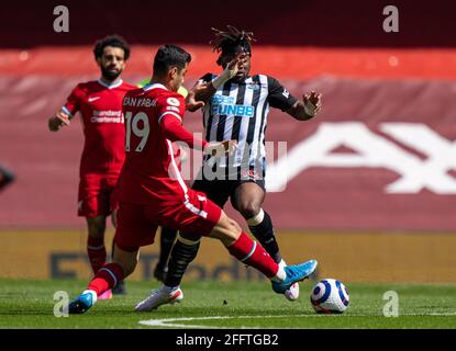 Liverpool. 25th Apr, 2021. Liverpool's Ozan Kabak (C) tackles Newcastle United's Allan Saint-Maximin (R) during the Premier League match between Liverpool and Newcastle United at Anfield in Liverpool, Britain, on April 24, 2021. Credit: Xinhua/Alamy Live News Stock Photo