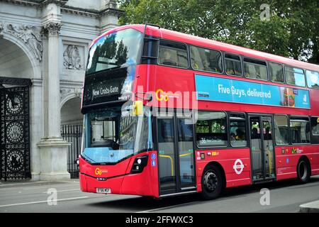 London, England, United Kingdom. A double-decker bus passing by Marble Arch. Red double-decker buses have long been a recognizable symbol of London. Stock Photo