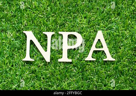 Alphabet letter in word NPA (Abbreviation of Non performing assets or Nasopharyngeal airway) on green grass background Stock Photo