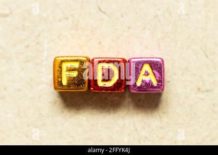 Metallic color alphabet letter block in word FDA (abbreviation of food and drug administration) on wood background Stock Photo