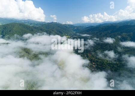 Aerial view drone shot of flowing fog waves on mountain tropical rainforest,Bird eye view image over the clouds Amazing nature background with clouds Stock Photo