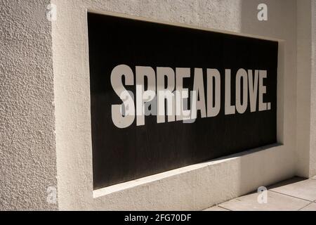Spread Love. Positive slogan painted on boarded-up window during protests. Stock Photo