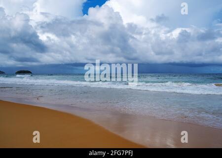 Dramatic dark storm white cloud over the sea with pouring rain in the distance over the Ocean along the shoreline,view looking from tranquil beach on Stock Photo