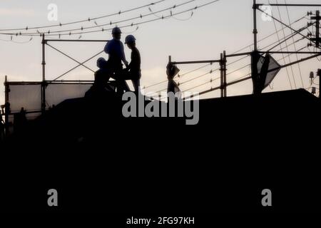 Men working on roof at construction site Stock Photo