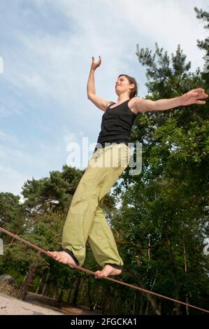 Woman balancing on Slackline in the forests of Fontainebleau Stock Photo