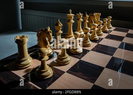 The opening of the chess game with the move of the white king pawn e2-e4,  copy space on a black background. A man hand with a chess piece in a board g