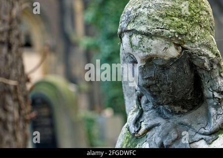 Cracked angel face - ancient statue at old cemetery Stock Photo
