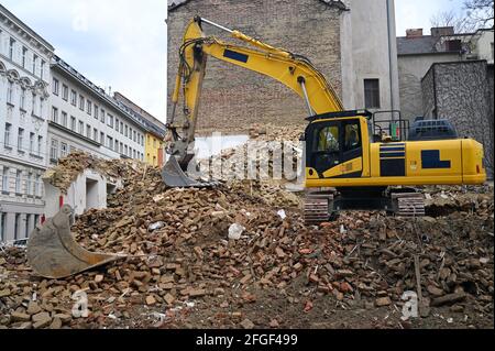 Earth moving machine tearing down an old building on a construction site Stock Photo