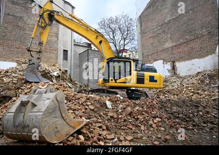 Earth moving machine tearing down an old building Stock Photo