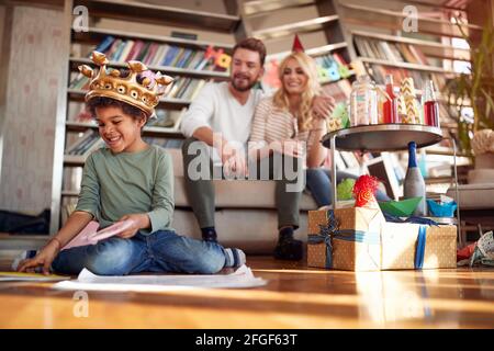 An adopted little boy having a good time with his family at a kids birthday party in a cheerful atmosphere. Family, celebration, together Stock Photo