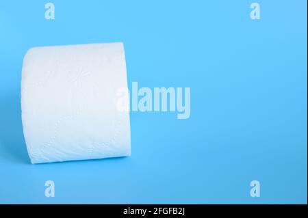 rolled white toilet paper in a blue background. space for text Stock Photo