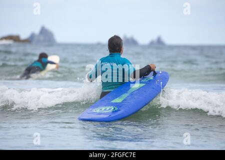 Galicia, Spain - August 2, 2020: Surf lessons on the beach of San Antonio, Espasante. Novice surfers, learning with their surfboards on a cloudy day, Stock Photo