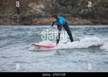 Galicia, Spain - August 2, 2020: Surf lessons on the beach of San Antonio, Espasante. Novice surfers, learning with their surfboards on a cloudy day, Stock Photo