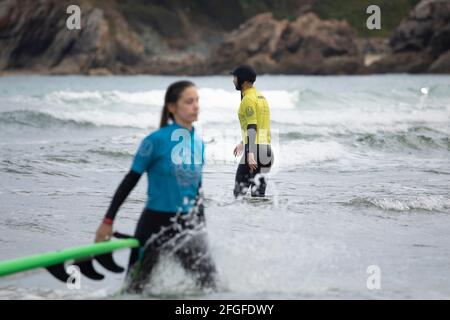 Galicia, Spain - August 2, 2020: Surf lessons on the beach of San Antonio, Espasante. Novice surfers, learning with their surfboards on a cloudy day, Stock Photo