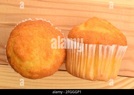 Two fragrant cupcakes on a wooden table, close-up, top view. Stock Photo