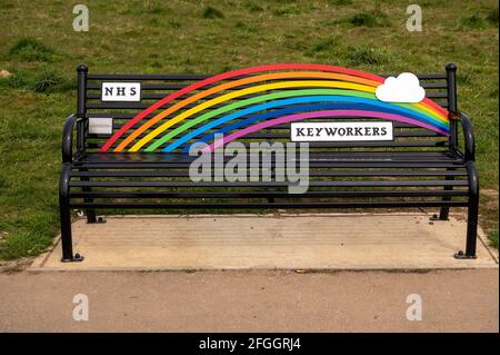 A rainbow colored park bench dedicated to the NHS and keyworkers during the pandemic covid 19 from the community of Costessey Norwich Norfolk England Stock Photo
