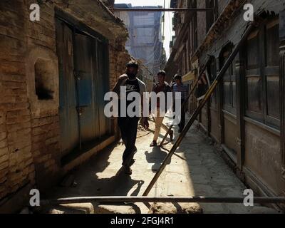 Kathmandu, Bagmati, Nepal. 25th Apr, 2021. People walk in between iron planks kept in support for houses damaged during massive earthquake 2015 at an alley in Kathmandu, Nepal on April 25, 2021. Nepal on Sunday marked the sixth anniversary of a devastating earthquake that killed almost 9,000 people and left millions homeless. Credit: Sunil Sharma/ZUMA Wire/Alamy Live News Stock Photo