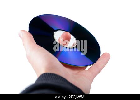 Hand holding up a CD or DVD disc, CD-ROM, DVD-ROM compact digital optical data storage, isolated on white, cut out. Data carriers, storage, storing in Stock Photo