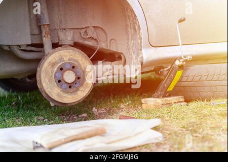 own repair of car drum brake himself. repair of broken car drum brake disassembled outdoor. flare Stock Photo