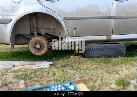 own repair of car drum brake himself. repair of broken car drum brake disassembled outdoor Stock Photo