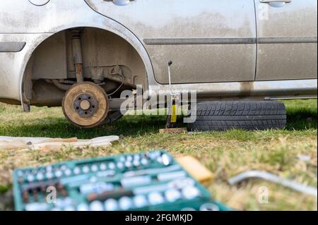 own repair of car drum brake himself. repair of broken car drum brake disassembled outdoor Stock Photo