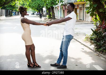 Young loving couple during a romantic day. Romantic man and woman on the date of the feast of love, they are holding hands in the street and laughing Stock Photo