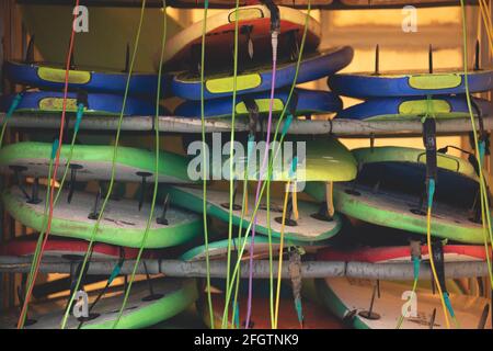 Galicia, Spain - August 4, 2020: A pile of surfboards and sports equipment with their leash stored in a van, near the beach of San Antonio, Espasante, Stock Photo