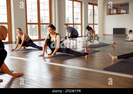 Group young woman doing yoga and stretching exercises in the Studio. Fitness class, sport and healthy lifestyle concept Stock Photo