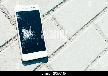 Phone lies on the road with a broken display. Stock Photo