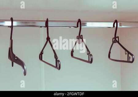 Clothes hangers in the empty closet of the apartment. Storage and order. Stock Photo