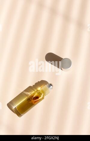 Top view of roller bottle on striped shadow beige background. Stock Photo