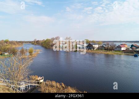 Spring flood in the village on a sunny day in spring. Landscape against a blue sky with white clouds Stock Photo