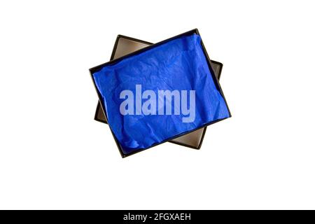 Opened black flat rectangular cardboard box with blue crumpled wrapping paper top view isolated on white Stock Photo