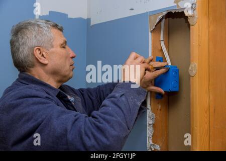 Electrical is installing new junction box to the beams Stock Photo