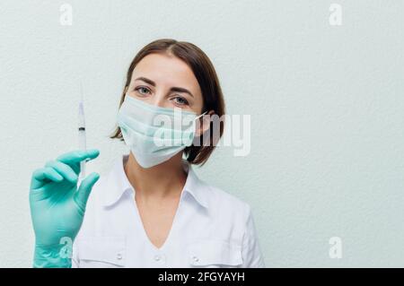 Young woman doctor holds a syringe in her hand. Flu concept Stock Photo